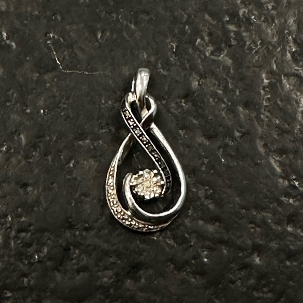 Kay Jewelers Black and white diamond pendant with large center stone.
